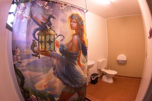 a shower curtain with a woman holding a lantern in a bathroom at Batchelor Butterfly Farm in Batchelor