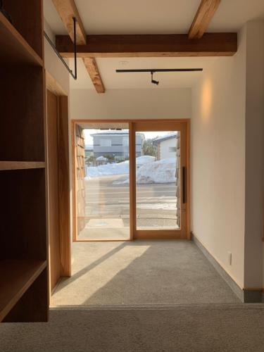 uma porta aberta para um quarto com uma porta de vidro em やどバーTATSUJi em Joetsu