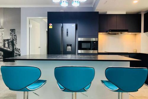 a kitchen with a counter with three blue chairs at Southbank Modern Luxe Apartment in Brisbane