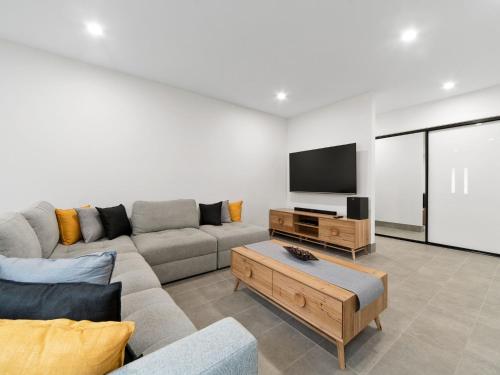 a living room with a couch and a flat screen tv at La Bella On Allambi in Capel Sound