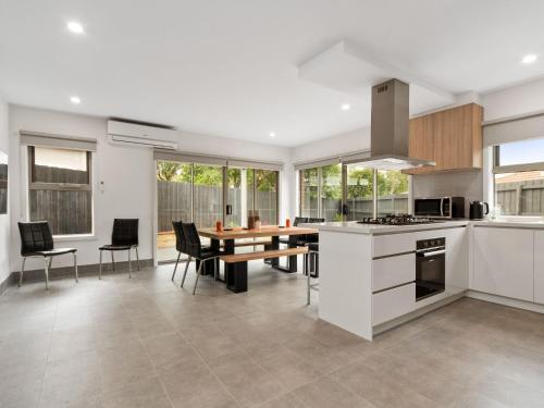 a kitchen and dining room with a table and chairs at La Bella On Allambi in Capel Sound