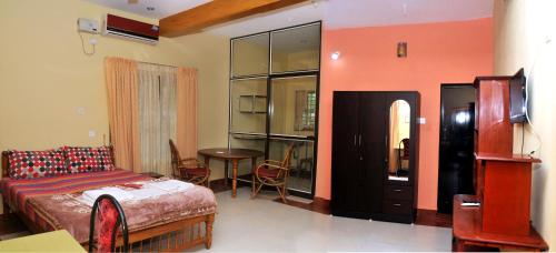 um quarto com uma cama e uma mesa em Karthika Plaza Resort Pvt Ltd em Varkala
