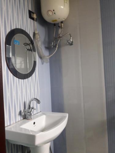 a bathroom with a sink and a mirror at Tharbaling HomeStay in Darjeeling