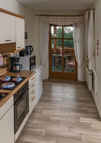 a kitchen with white cabinets and a stove top oven at Eulenberghof Kraus in Altenkunstadt