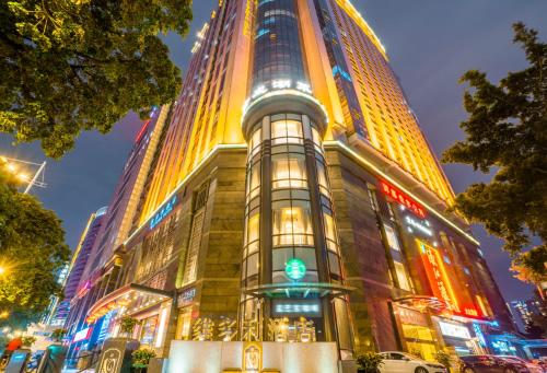 a tall building with lights on it at night at Victoria Hotel Guangzhou Zhujiang New Town - Free shuttle bus during Canton Fair period in Guangzhou