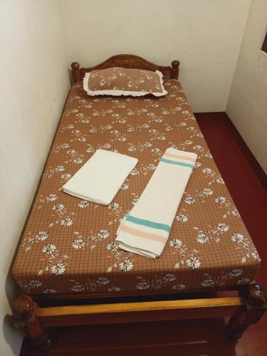 a table with a bed with a blanket and napkins at Marari Beach Villas in Mararikulam