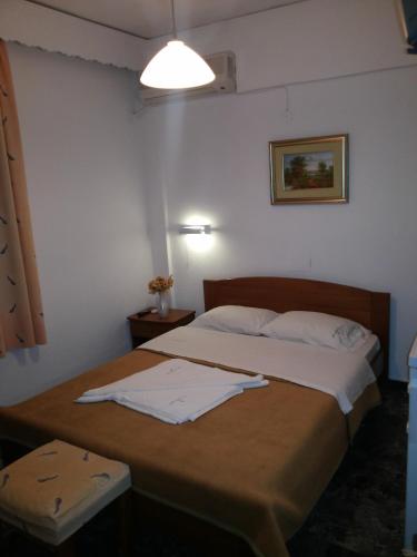 a bedroom with two beds with white sheets at San Georgio Hotel in Tsoútsouros