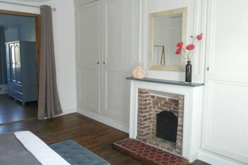 ein Wohnzimmer mit einem gemauerten Kamin und einem Spiegel in der Unterkunft Gîte Liralou Baie de Somme in Le Titre