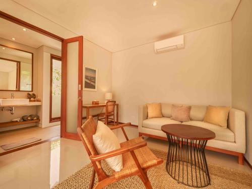 a living room with a couch and a table at Agra & Amurti Villas in Munggu