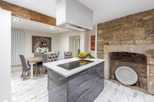 a kitchen and dining room with a stone fireplace at Lovely 4 Bedroom townhouse in Bath