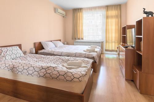 a bedroom with two beds and a couch at Like home in Burgas