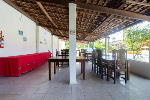 a dining room with tables and chairs and a red table cloth at Pousada Do Inglês in Jacumã