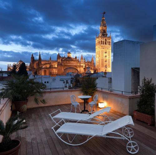 un balcón con vistas a un edificio con una torre de reloj en Hotel Casa 1800 Sevilla, en Sevilla
