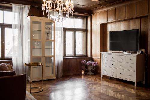 een woonkamer met een televisie op een wit dressoir bij Concert Hall boutique apartment in Cēsis
