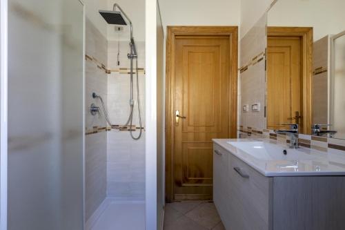 a white bathroom with a sink and a shower at Red Passion Beach in Alghero