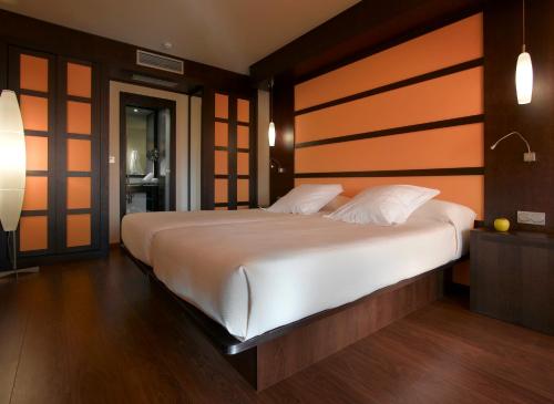 a bedroom with a large white bed with a wooden headboard at Hotel Abades Nevada Palace in Granada