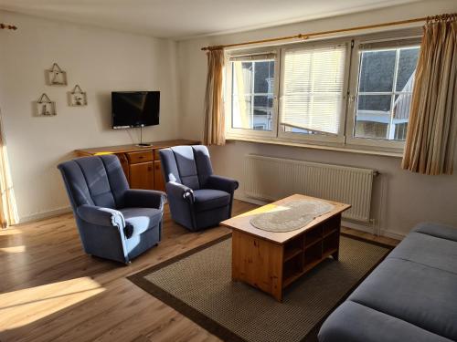 a living room with two chairs and a tv at Hotel Seelust in Hohwacht