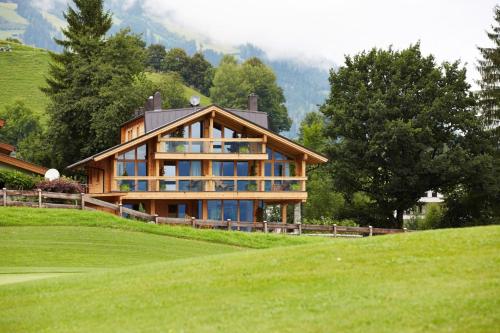 a large house on top of a green hill at ZillerLodge in Uderns