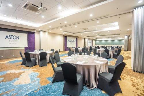 a conference room with tables and chairs and a projection screen at Aston Anyer Beach Hotel in Anyer