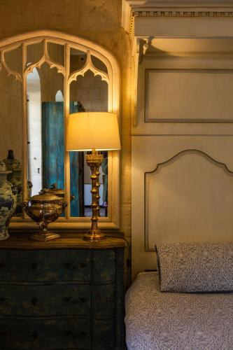 a bedroom with a bed with a lamp and a dresser at Palazzino Birgu Host Family Bed and Breakfast in Vittoriosa