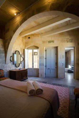 a bedroom with a bed with towels on it at Palazzino Birgu Host Family Bed and Breakfast in Vittoriosa