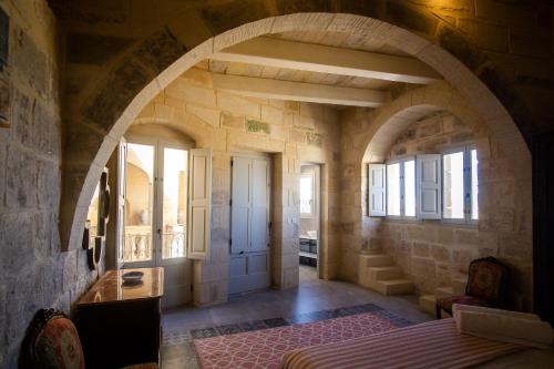 a large room with an archway in a building at Palazzino Birgu Host Family Bed and Breakfast in Vittoriosa