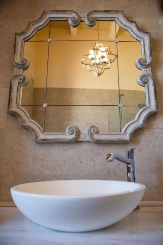 a bathroom sink with a large mirror on the wall at Palazzino Birgu Host Family Bed and Breakfast in Vittoriosa