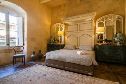 a bedroom with a bed and a large mirror at Palazzino Birgu Host Family Bed and Breakfast in Vittoriosa