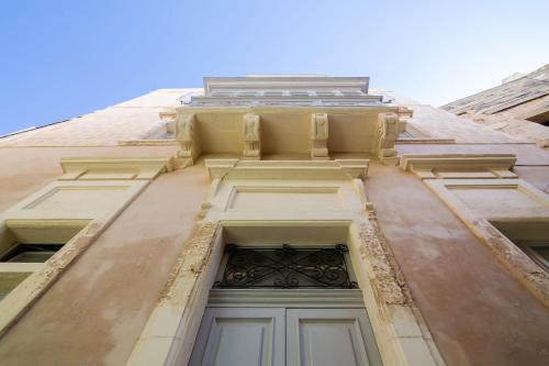 a tall building with a window and a door at Palazzino Birgu Host Family Bed and Breakfast in Vittoriosa