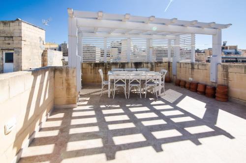a table and chairs on the roof of a building at Palazzino Birgu Host Family Bed and Breakfast in Vittoriosa