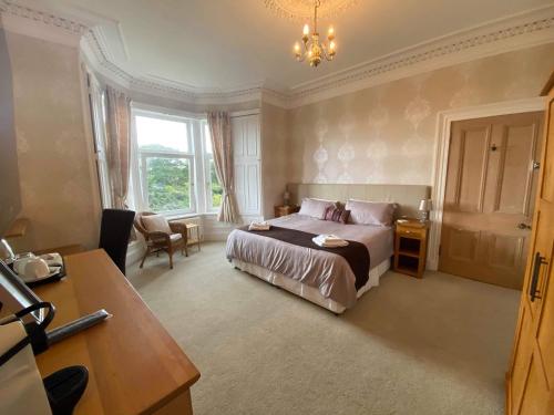 a hotel room with a bed and a desk and a desk at Park House in Carnoustie
