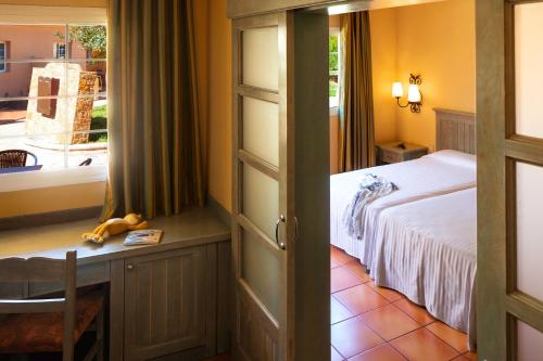 a bedroom with a bed and a table and a window at Royal Suite in Costa Calma