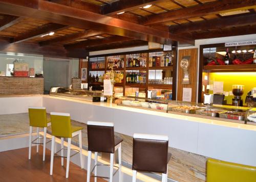 a bar with green chairs and a counter at Hostal El Vegano in Utiel