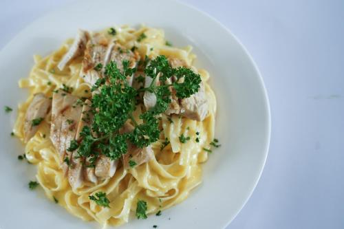 a plate of pasta with meat and parsley on it at La Bella Boutique Hotel in Tagaytay