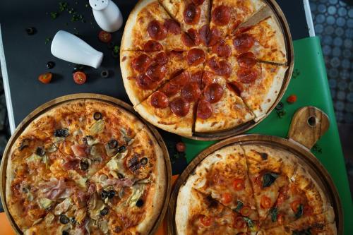 three pizzas sitting on top of a table at La Bella Boutique Hotel in Tagaytay