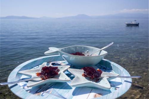 a bowl of food on a glass table next to the water at Avgi by the Sea in Kala Nera