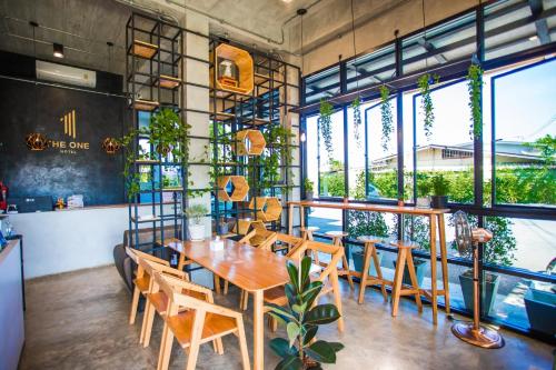 comedor con mesa, sillas y ventanas en The one hotel สวนผึ้ง en Ratchaburi