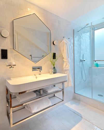 une salle de bain avec un lavabo, un miroir et une douche dans l'établissement Le Katorze Hôtel, à Paris