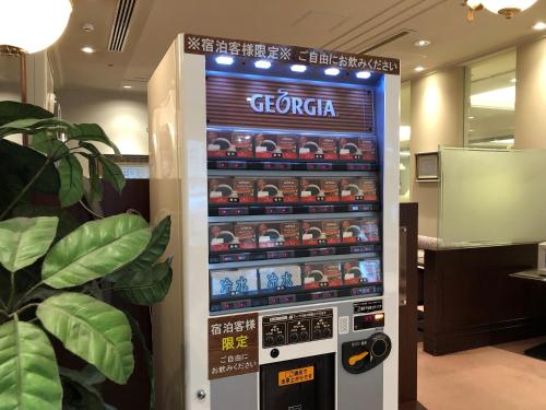 an electronic vending machine in a room with a plant at Hotel Sunroute Niigata in Niigata