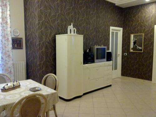 - un salon avec un réfrigérateur blanc et une table dans l'établissement B&B Anfiteatro Campano, à Santa Maria Capua Vetere