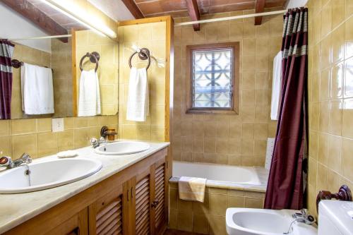 a bathroom with two sinks and a tub at Villa Rosa in Pollença