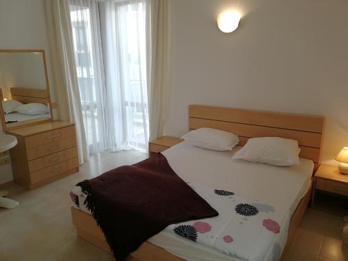 a bedroom with a large bed and a mirror at Cozy family villa 500m. from the beach in Byala