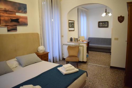 a hotel room with a bed and a chair at La Casa del Mercante Veneziano in Venice
