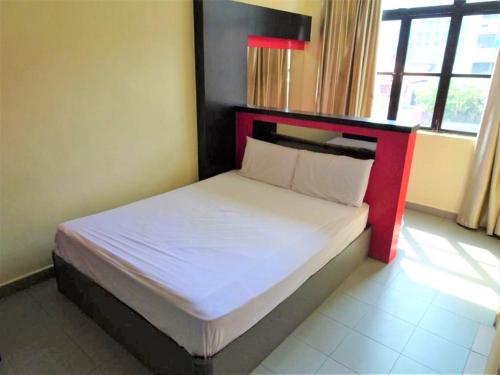 a bedroom with a bed with a red headboard at SENG WAH HOTEL in Singapore