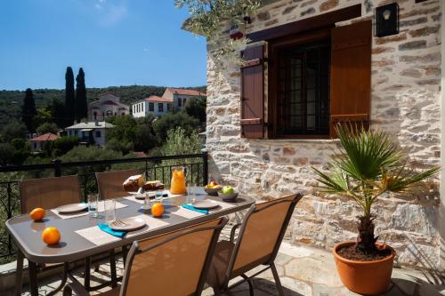 a table and chairs on the balcony of a house at Villa Ioanna by Pelion Esties in Áno Gatzéa