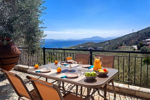 a table with fruit on it on a balcony at Villa Ioanna by Pelion Esties in Áno Gatzéa