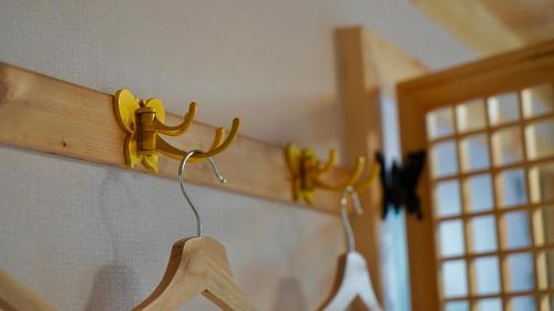 a wooden rack with hangers on a wall at The Jeongga in Jeonju