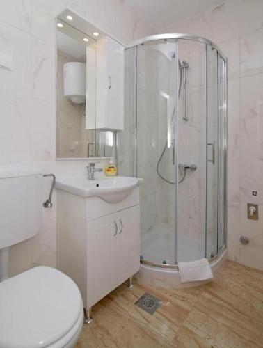 a bathroom with a shower and a toilet and a sink at Apartments M&P in Mlini