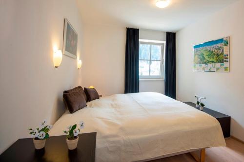 a bedroom with a large bed and a window at Sonnenwende by AlpenTravel in Bad Gastein