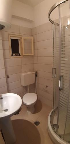 a bathroom with a toilet and a sink and a shower at Sea and joy in Iraklitsa